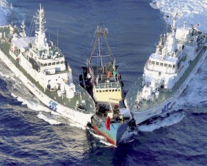Bateau de pêche, avec à bord des activistes chinois, coincé par deux garde-côtes japonais, le 15 août 2012, près de l’archipel des Senkaku, en mer de Chine orientale